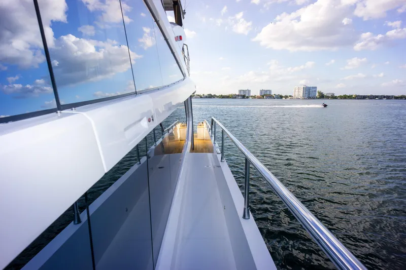  Yacht Photos Pics Luxury Pearl 80 yacht on water, reflecting sky and clouds, 2020 model.