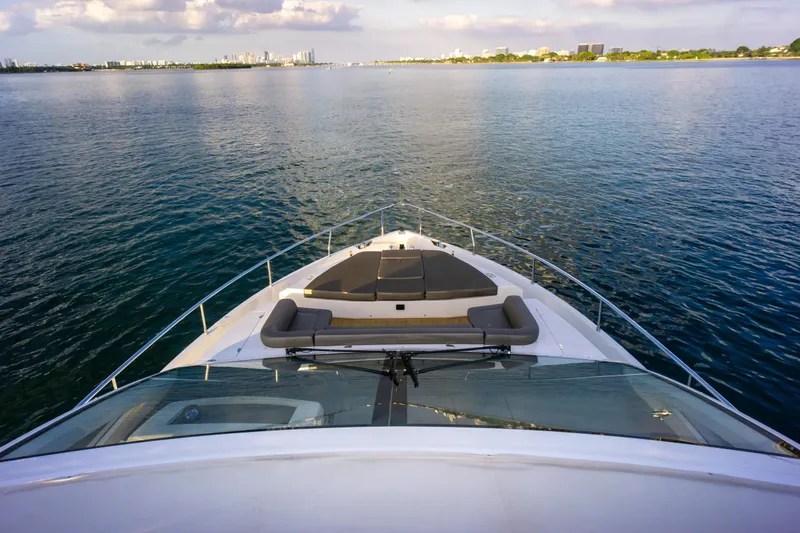 Yacht Photos Pics Bow view of 2020 Pearl 80 yacht cruising on calm waters under a cloudy sky.