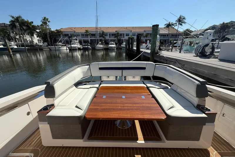  Yacht Photos Pics 2019 Tiara Sport 38 LS yacht with elegant seating and wooden table in marina setting.