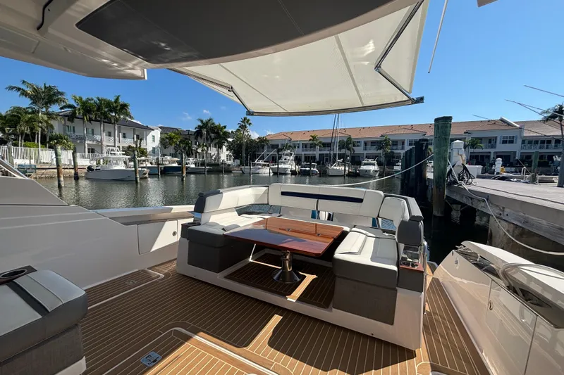  Yacht Photos Pics 2019 Tiara Sport 38 LS yacht interior with seating and table, docked in a marina.