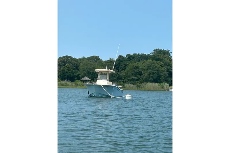  Yacht Photos Pics 2023 Grady-White Fisherman 257 boat anchored on a calm lake with trees in background.