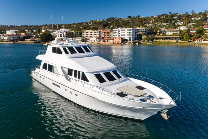 Rising Tide Yacht Photos Pics 1997 Forbes Cooper Pilothouse yacht cruising near coastal residential area.