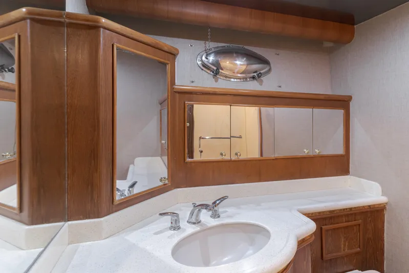 Rising Tide Yacht Photos Pics Luxurious bathroom in 1997 Forbes Cooper Pilothouse yacht with wooden cabinetry and modern fixtures.