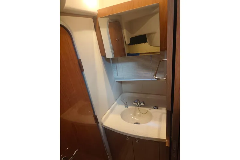  Yacht Photos Pics 2007 Regal Commodore 4060 bathroom with sink, mirror, and wooden cabinetry.