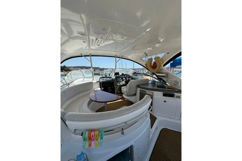  Yacht Photos Pics 2007 Regal Commodore 4060 yacht interior with seating, table, and helm in a marina setting.