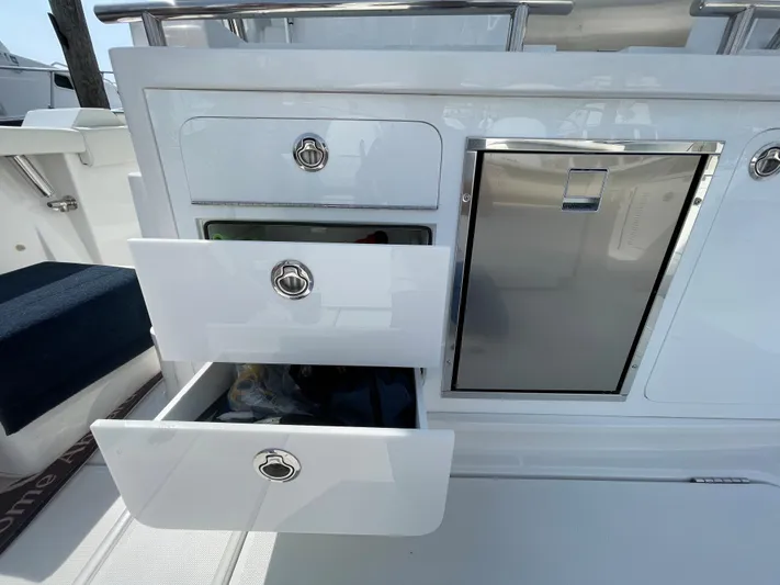  Yacht Photos Pics 2022 Bertram 39 CC boat interior with open storage drawers and stainless steel cabinet.