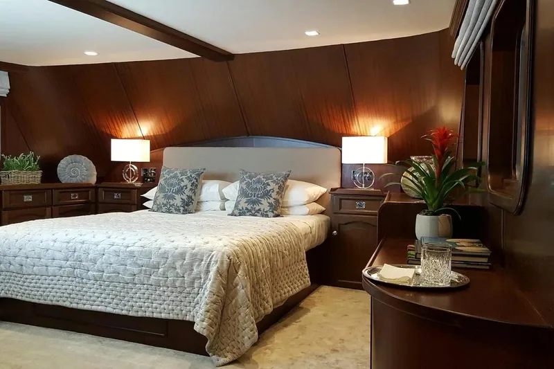  Yacht Photos Pics Luxurious bedroom interior on a 1975 Custom 39M yacht, featuring elegant wood paneling and cozy lighting.