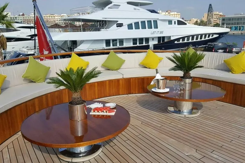  Yacht Photos Pics Luxurious yacht deck with seating, tables, and vibrant cushions; Custom 39M, 1975 model.