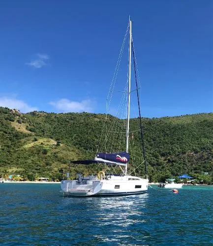 Aita Pea Pea III Yacht Photos Pics 2020 Beneteau Oceanis 46.1 sailboat on clear blue water near lush green hills.