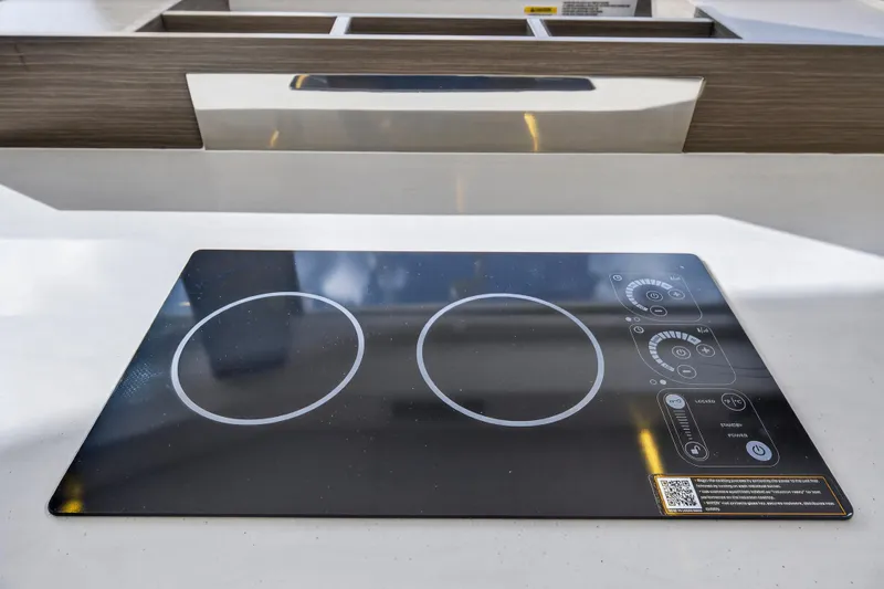  Yacht Photos Pics Modern induction cooktop on Leopard 46 yacht, 2025 model, featuring sleek design and digital controls.