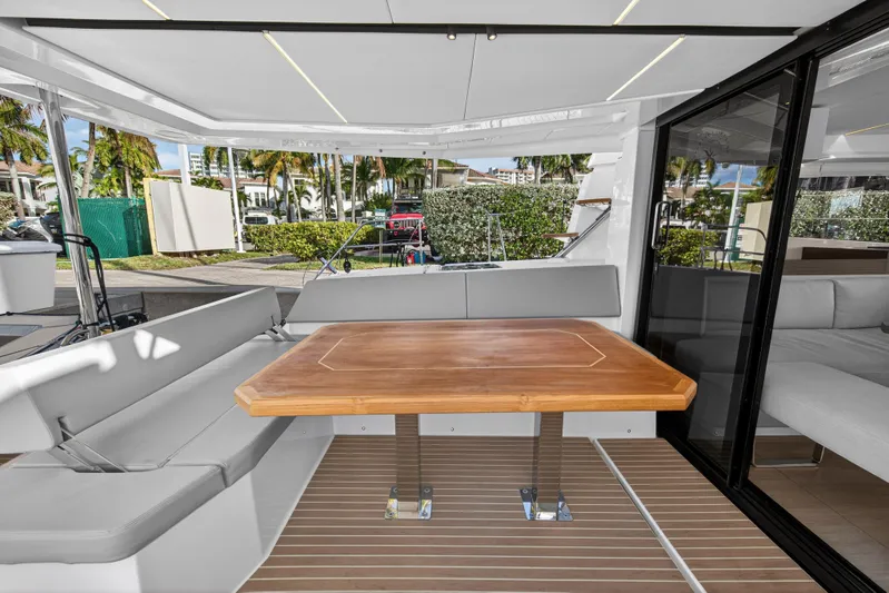  Yacht Photos Pics Luxurious Leopard 46 yacht interior, featuring a sleek wooden table and comfortable seating, 2025 model.