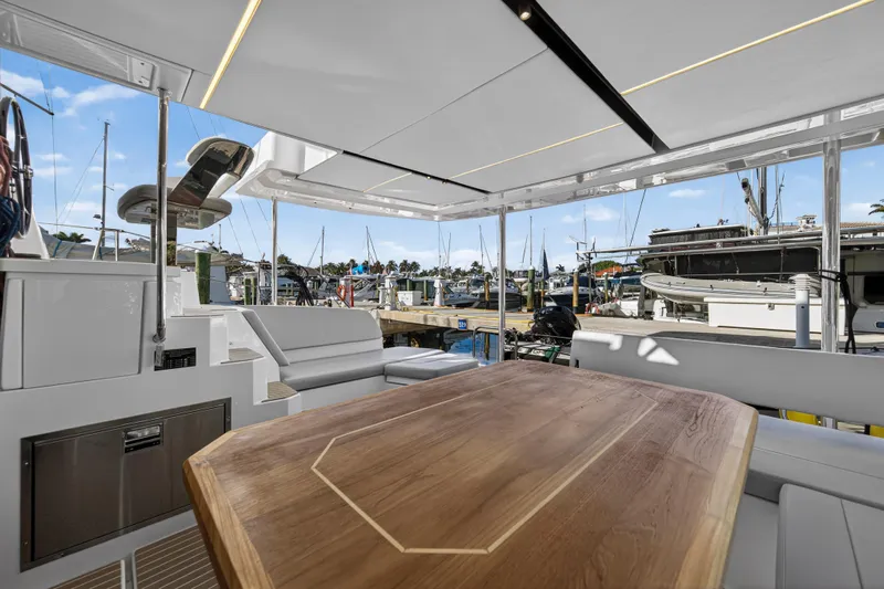  Yacht Photos Pics Luxurious 2025 Leopard 46 yacht interior with elegant wood table and marina view.