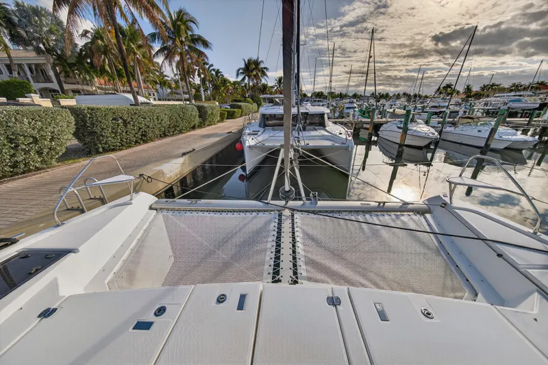  Yacht Photos Pics Leopard 46 catamaran docked at marina, surrounded by palm trees and other boats, 2025 model.