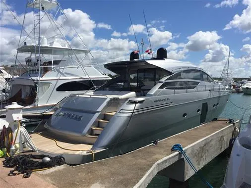 2010 Pershing 64' yacht docked at marina under blue sky.