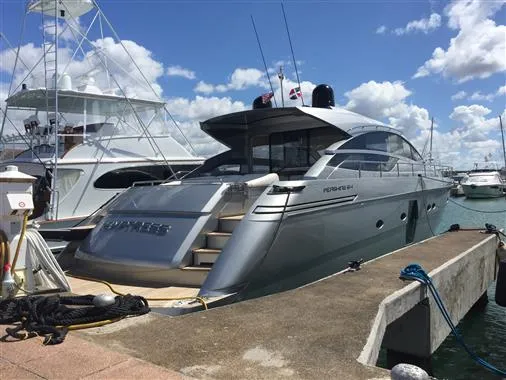 Luxury 2010 Pershing 64' yacht docked at marina under blue sky.