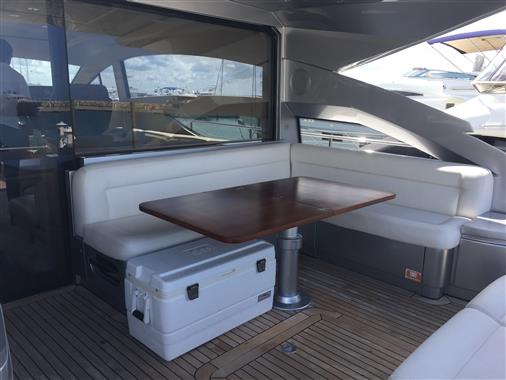 Luxurious 2010 Pershing 64' yacht interior with elegant seating and wooden table.