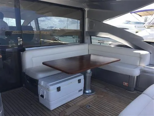 Luxurious 2010 Pershing 64' yacht interior with elegant seating and wooden table.