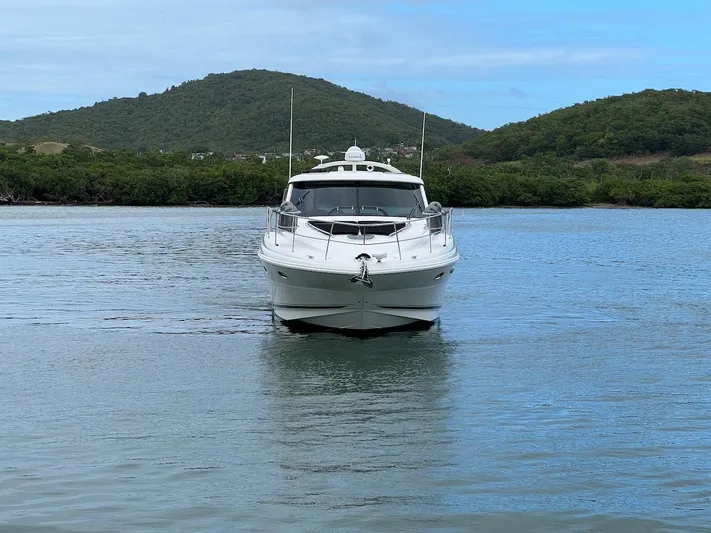  Yacht Photos Pics 2006 Sea Ray 48 Sundancer on calm water with green hills.