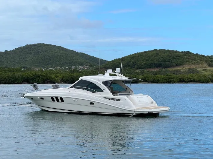  Yacht Photos Pics 2006 Sea Ray 48 Sundancer on calm water with green hills.