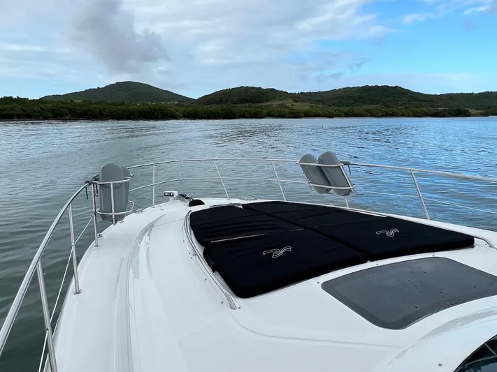  Yacht Photos Pics 2006 Sea Ray 48 Sundancer on calm waters with green hills.