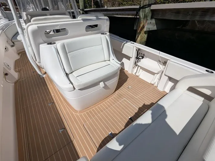  Yacht Photos Pics Intrepid 327 Center Console 2019 boat interior with white seating and wood-style flooring.