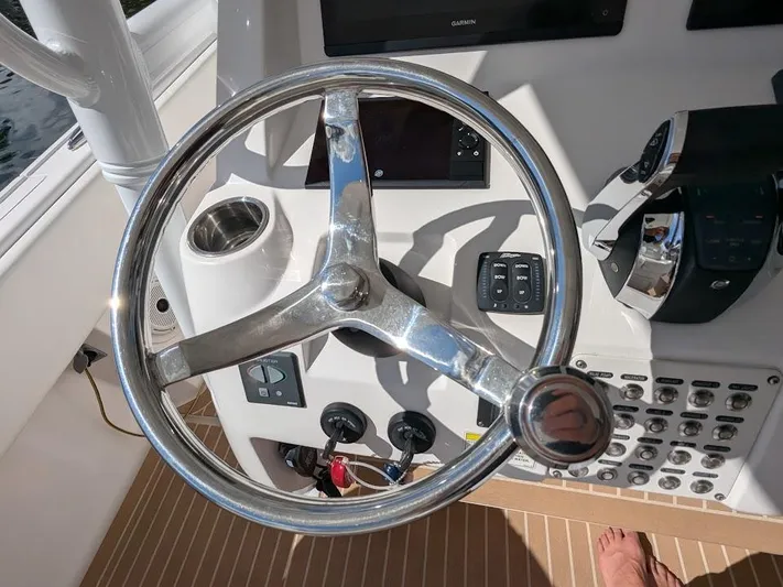  Yacht Photos Pics Steering wheel of a 2017 Intrepid 327 Center Console boat with control panel.
