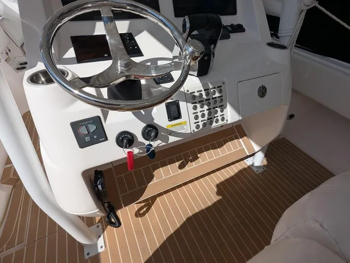  Yacht Photos Pics Steering console of 2017 Intrepid 327 Center Console boat with controls and teak flooring.
