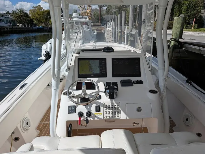  Yacht Photos Pics Intrepid 327 Center Console 2019, featuring advanced navigation and controls, docked by the water.