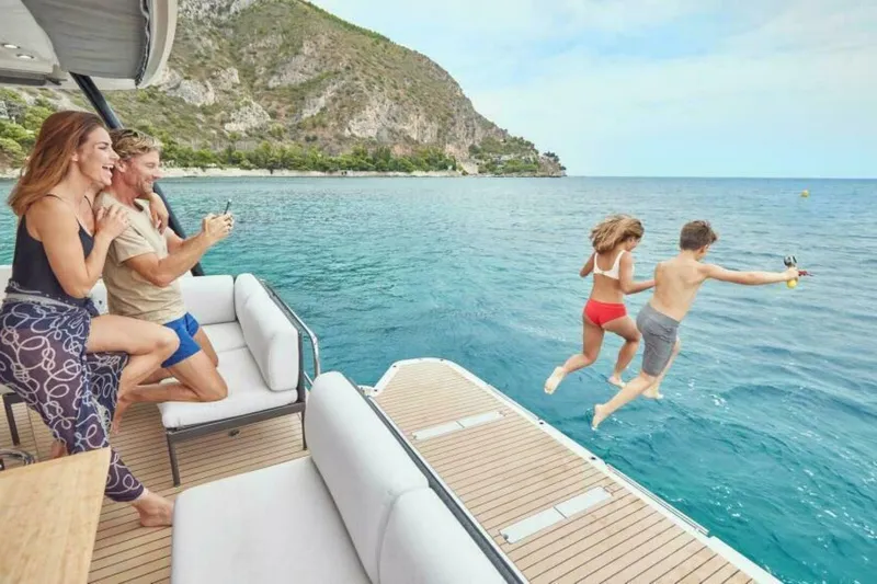 New 2026 Prestige M48 Multihull Yacht Photos Pics Family enjoying a day on a 2026 Prestige M48 yacht, kids jumping into the sea.