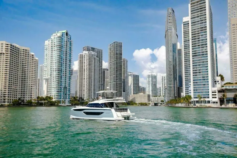 New 2026 Prestige M48 Multihull Yacht Photos Pics Prestige M48 yacht cruising near city skyscrapers, 2026 model.