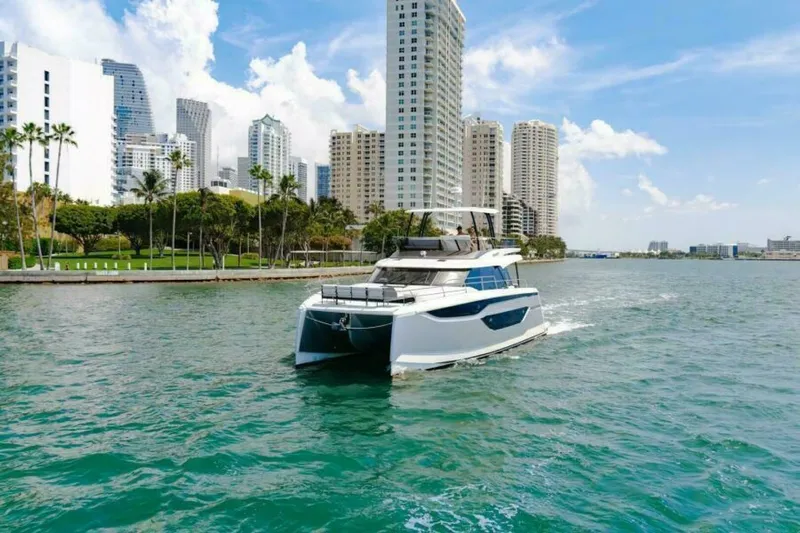 New 2026 Prestige M48 Multihull Yacht Photos Pics Luxury Prestige M48 yacht cruising near city skyline, 2026 model.