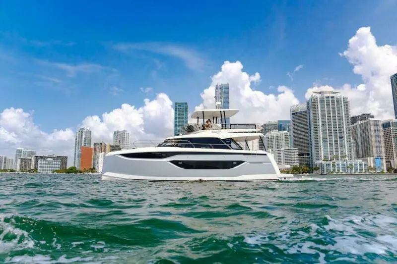 New 2026 Prestige M48 Multihull Yacht Photos Pics Luxury Prestige M48 yacht cruising near city skyline, 2026 model.