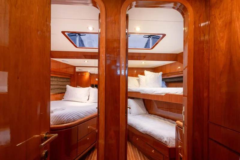 Kismet Yacht Photos Pics Luxurious 2003 Hargrave Skylounge yacht interior with elegant wood finish and cozy bedding.