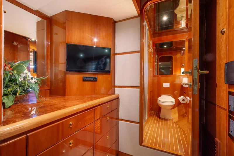Kismet Yacht Photos Pics Luxurious 2003 Hargrave Skylounge yacht interior with wood finish, TV, and bathroom.