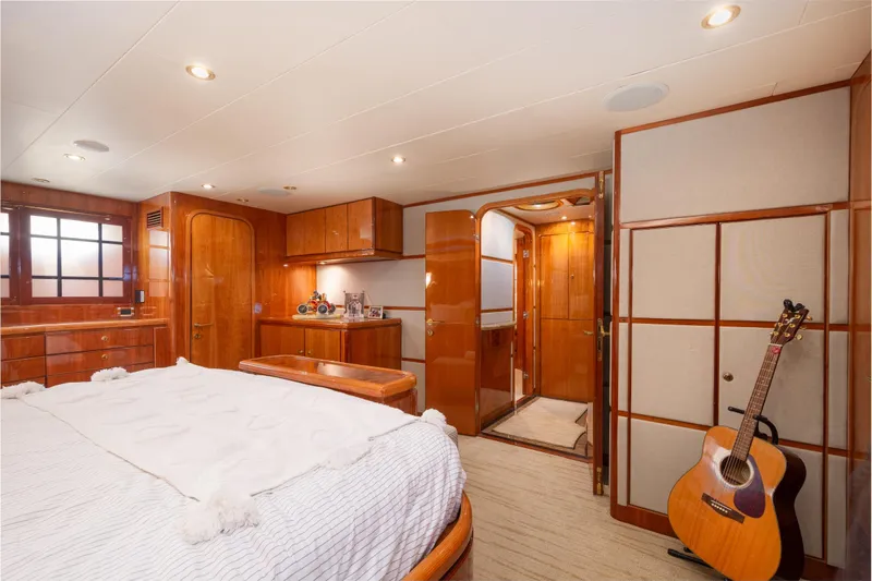 Kismet Yacht Photos Pics Luxurious 2003 Hargrave Skylounge yacht bedroom with wood paneling and acoustic guitar.