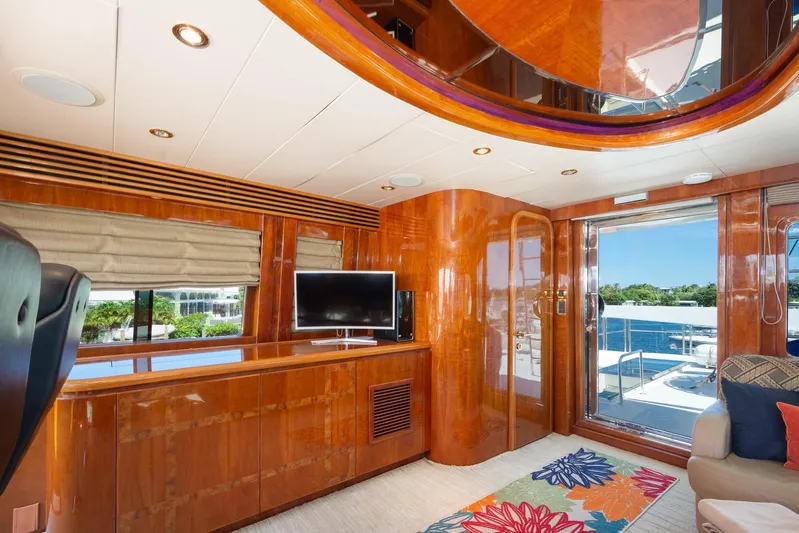 Kismet Yacht Photos Pics Luxurious 2003 Hargrave Skylounge interior with polished wood, TV, and vibrant decor.