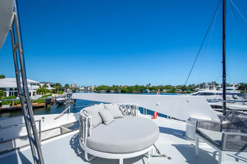 Kismet Yacht Photos Pics Luxurious 2003 Hargrave Skylounge yacht deck with round sunbed and waterfront view.