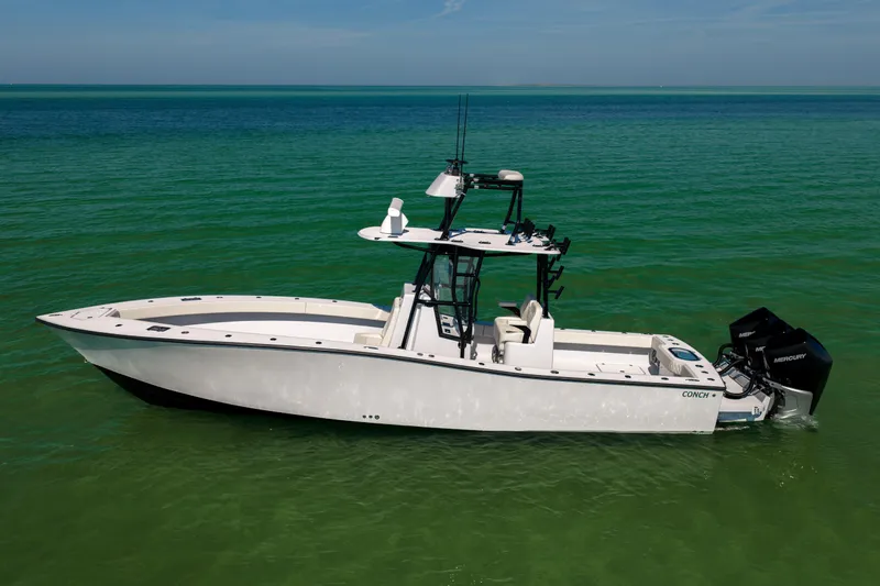  Yacht Photos Pics 2025 Conch 33 boat on clear green water, featuring sleek design and powerful outboard engines.
