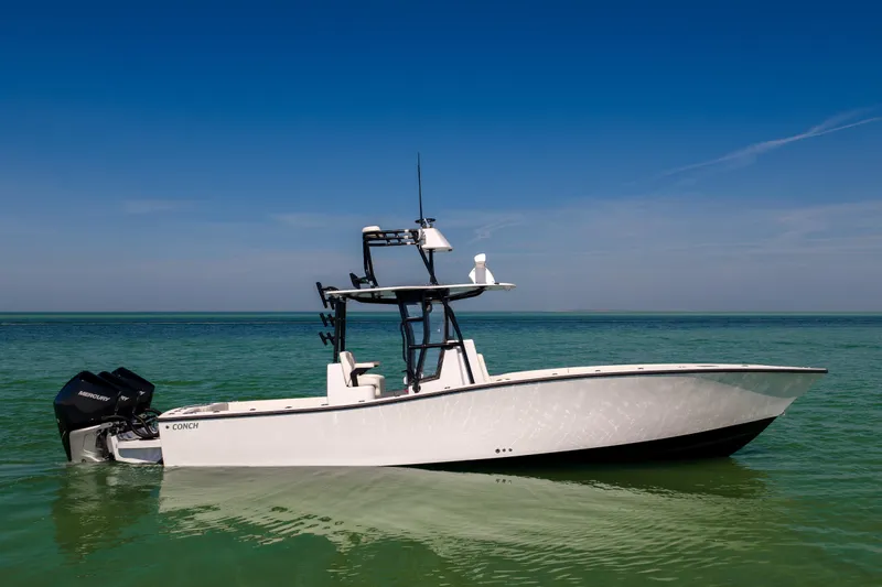  Yacht Photos Pics 2025 Conch 33 boat on calm turquoise water under clear blue sky.