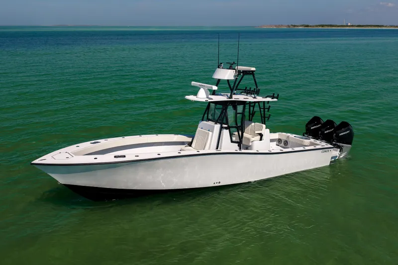  Yacht Photos Pics 2025 Conch 33 boat on clear green water, featuring triple outboard engines.
