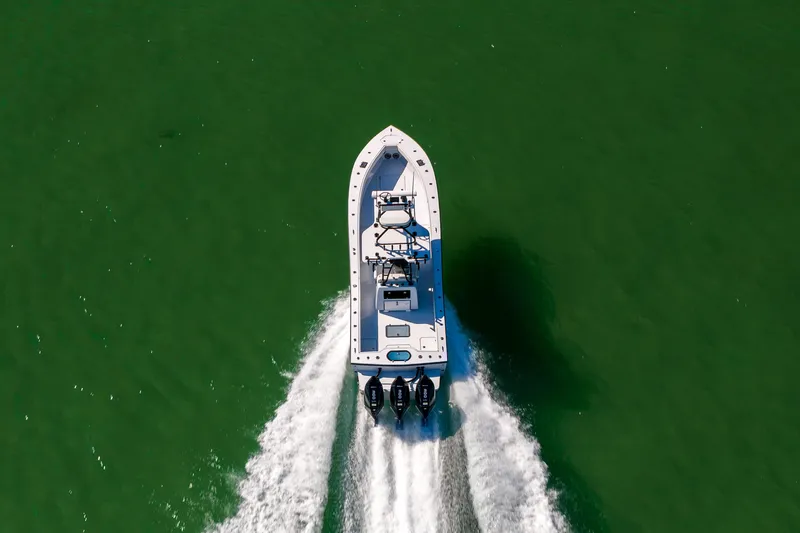  Yacht Photos Pics Aerial view of 2025 Conch 33 boat cruising on green water.