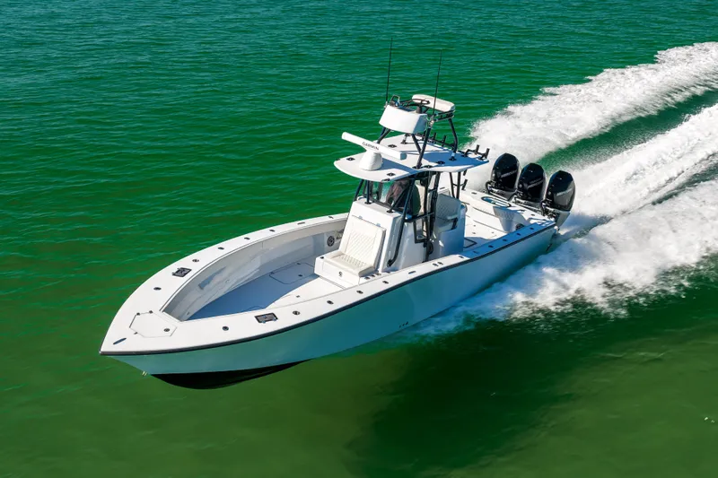  Yacht Photos Pics 2025 Conch 33 boat cruising on clear green water, showcasing sleek design and powerful engines.