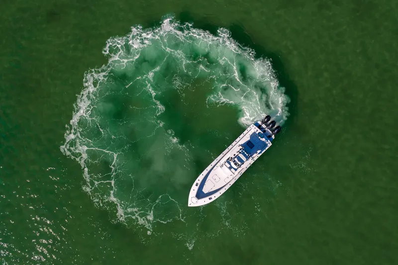  Yacht Photos Pics Aerial view of 2025 Conch 33 boat making a circular wake in green water.