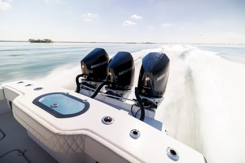  Yacht Photos Pics 2025 Conch 33 boat with triple Mercury engines speeding on open water.
