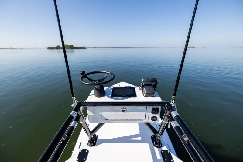  Yacht Photos Pics 2025 Conch 33 boat helm on calm water, clear sky, and distant islands.