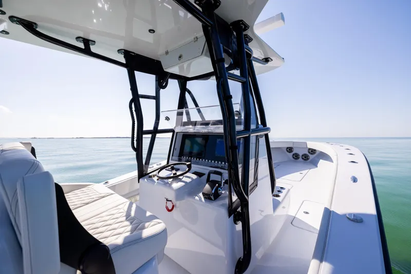  Yacht Photos Pics 2025 Conch 33 boat interior with modern helm and seating on calm water.
