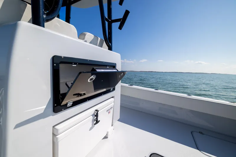 Yacht Photos Pics 2025 Conch 33 boat interior with open storage compartment, ocean view in background.
