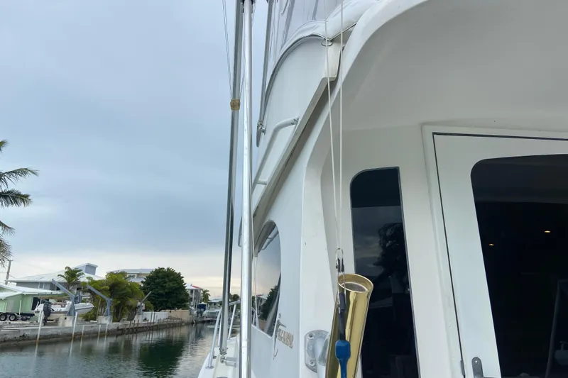 Belle La Vie Sur La Mer Yacht Photos Pics Egg Harbor 37 Convertible yacht, 2001 model, docked by a canal with palm trees.