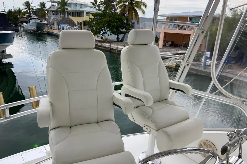 Belle La Vie Sur La Mer Yacht Photos Pics Captain's chairs on 2001 Egg Harbor 37 Convertible yacht, docked by waterfront homes.