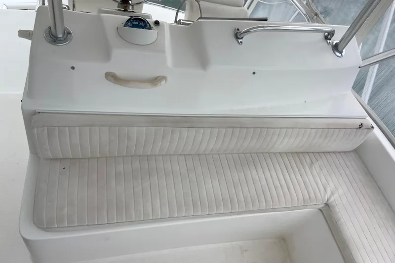 Belle La Vie Sur La Mer Yacht Photos Pics 2001 Egg Harbor 37 Convertible boat interior with white cushioned seating and helm controls.